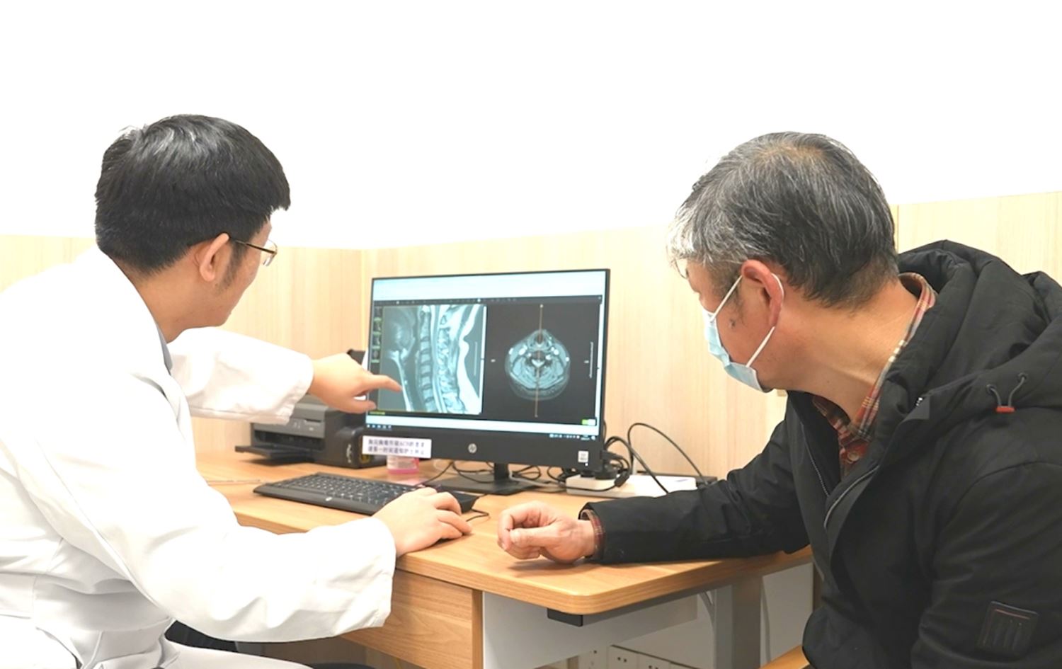 نەخۆشێک لەگەڵ پزیشکەکەی سەیری پشکنینەکەی دەکەن.