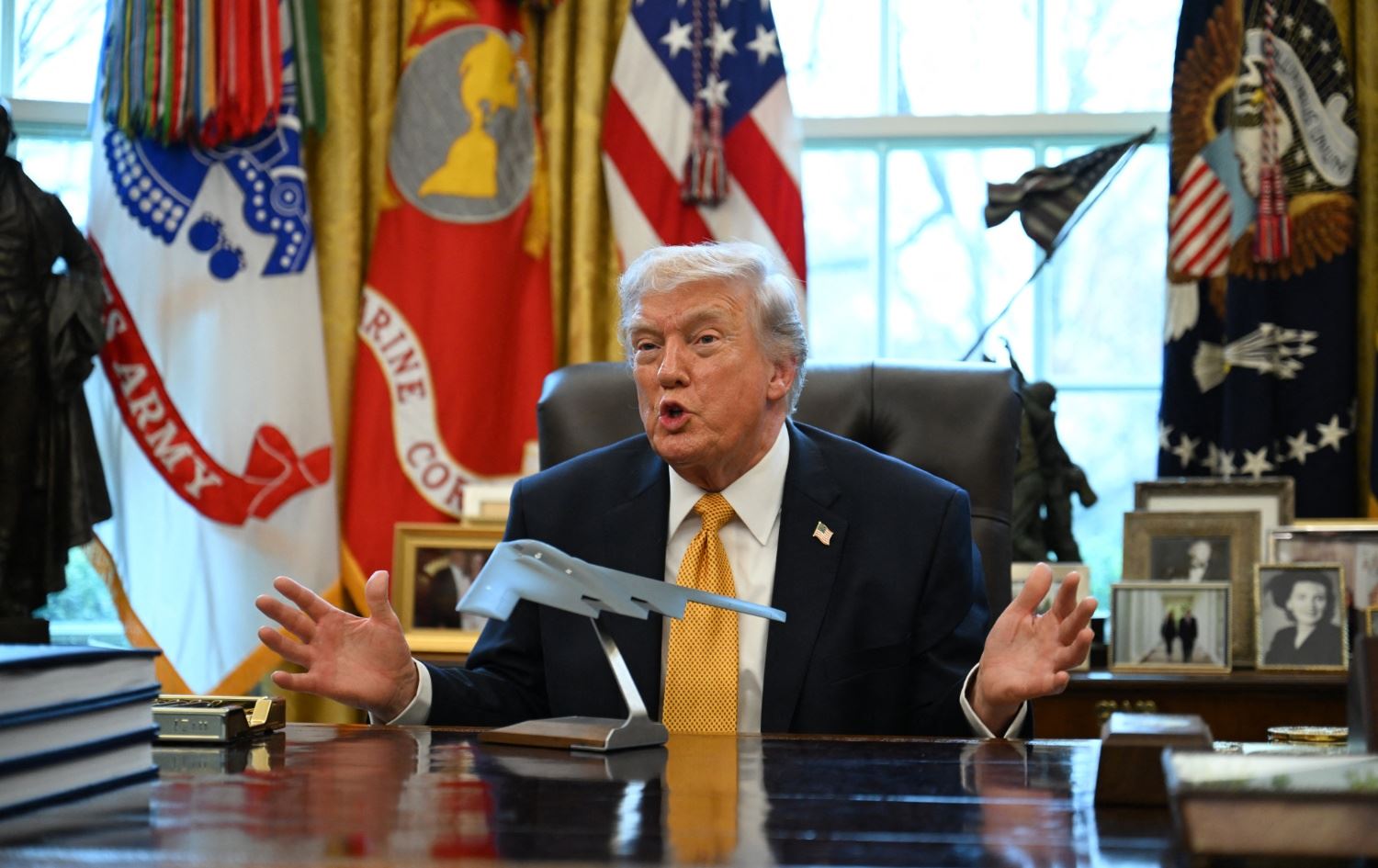 دۆناڵد ترەمپ لە ئۆڤاڵ ئۆفیس فڕۆکەیەکی جەنگی لە بەردەم خۆی داناوە و باسی جەنگ دەکات. وێنە: AFP