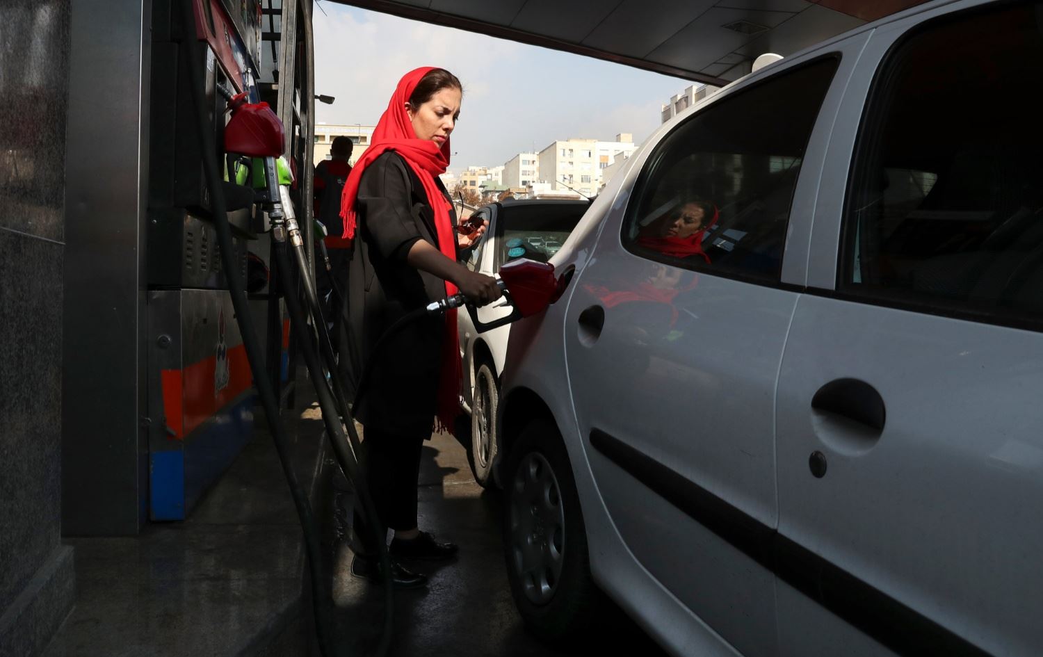 ژنێک بەنزین دەکاتە نێو ئۆتۆمبێل