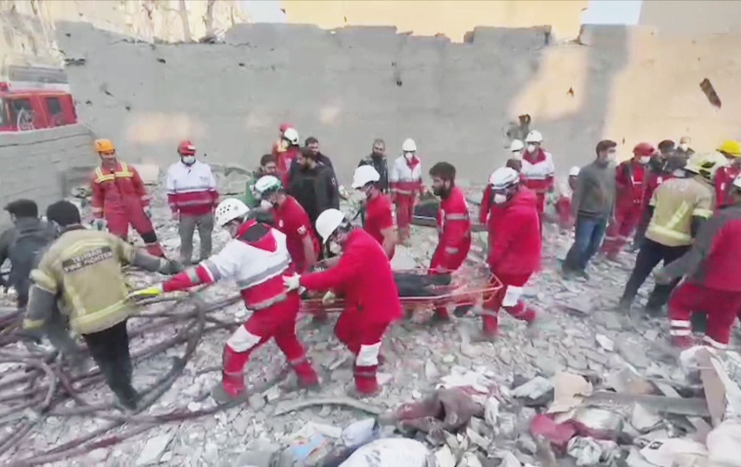 کارمەندانی فریاکەوتن قوربانییەکان لەژێر دار و پەردووی بۆردوومانێکدا دەردەهێنن.