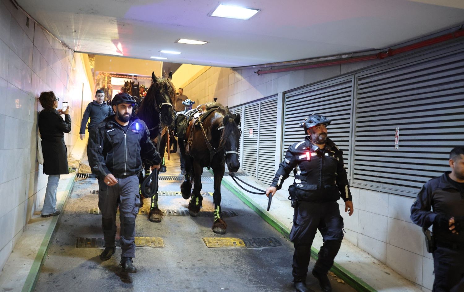  دوو پۆلیسی ئیسرائیل ئەسپەکانیشیان لەگەڵ خۆیان دەبەنە پەناگەیەک، دوای ئەوەی زەنگی ئاگادارکردنەوە لێدەدرێت. وێنە: AFP