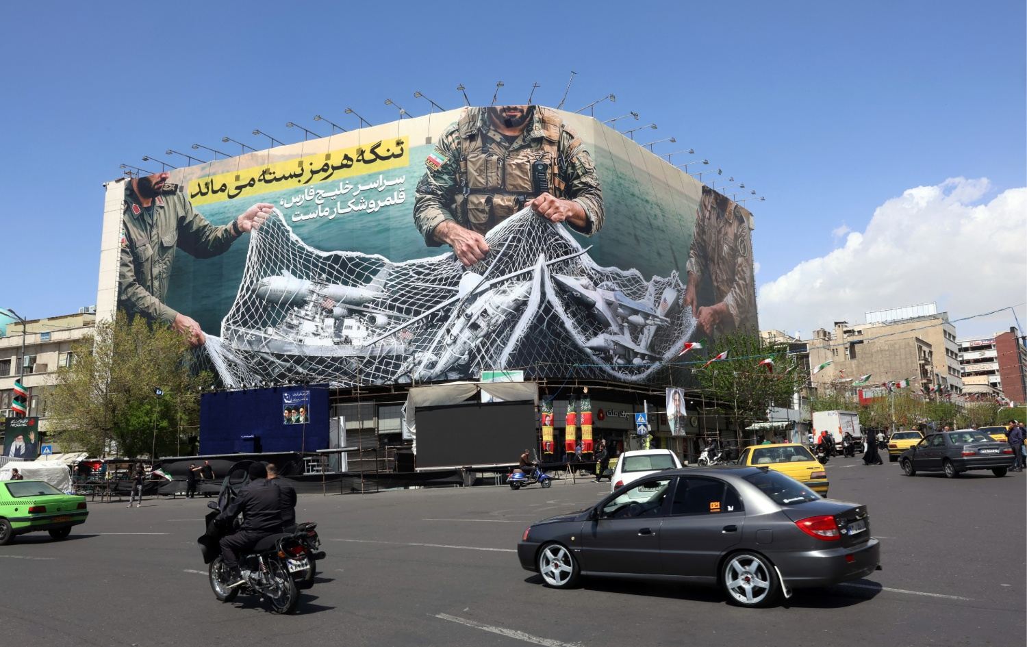 ئەمریکا داوای کردنەوەی تەنگەی هورمز دەکات و ئێران ئەم بانەرەی لە تاران هەڵواسیوە باس لە نەکرانەوەی دەکات. وێنە: AFP