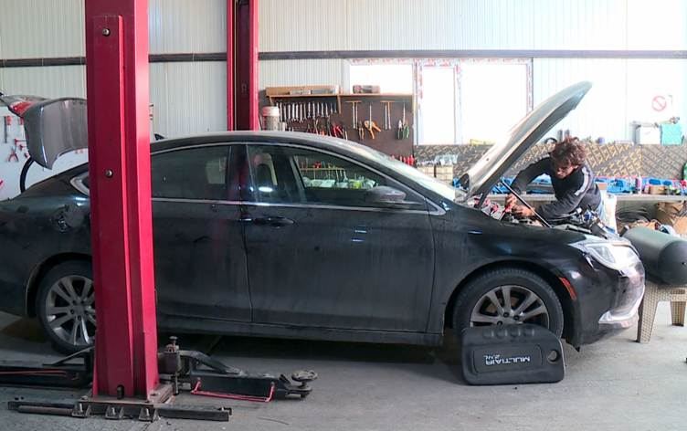 وەستایەکی چاککردنەوەی ئۆتۆمبێل لە کاتی کارکردن لە بزوێنەرێک