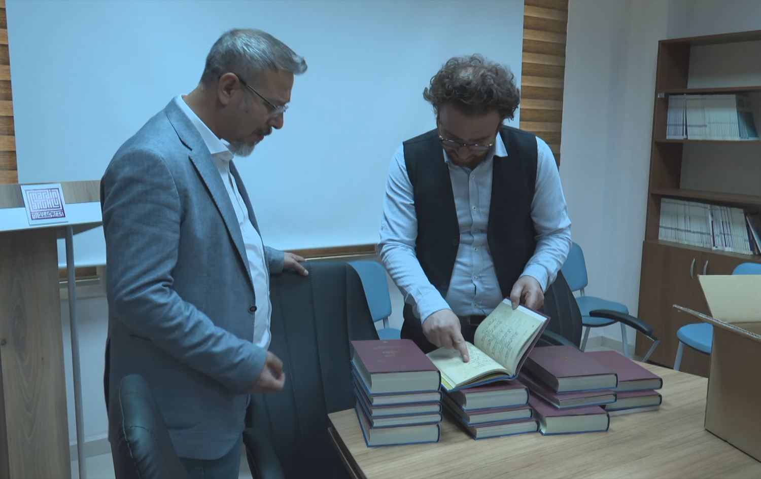 إبراهيم تاردوش، رئيس قسم اللغة الكوردية في جامعة آرتوكلو وماشالله دكاك، مراسل رووداو ومعهما المجلدات المطبوعة حديثاً
